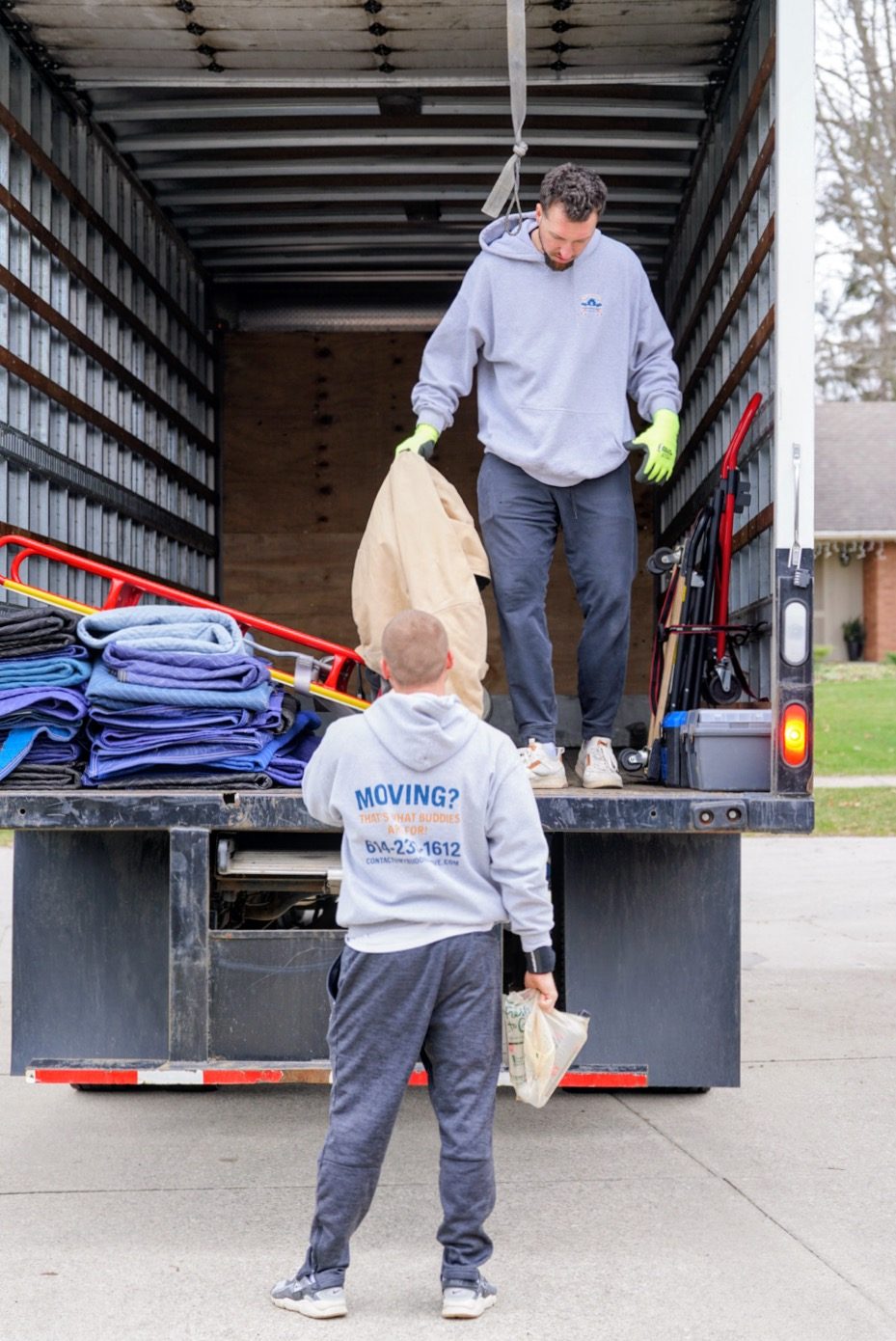 Movers wrapping and loading furniture